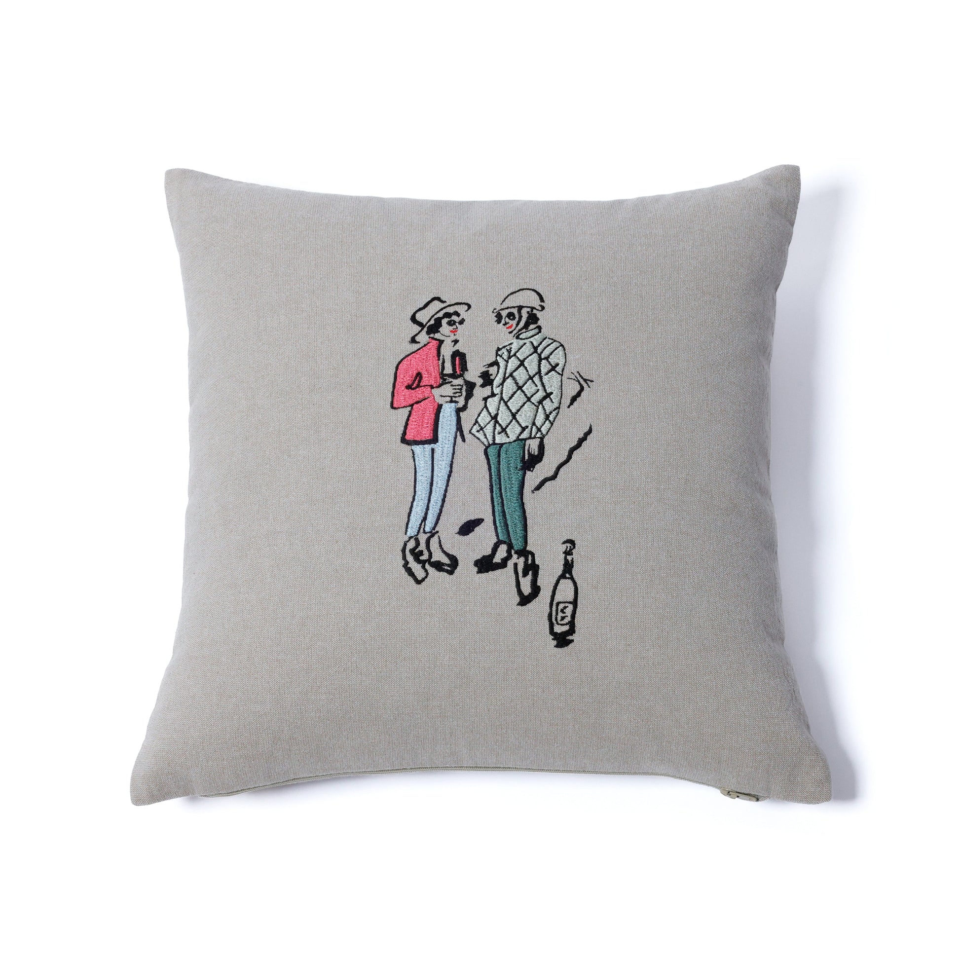 Gray pillow with embroidered design of two people and a bottle on a white background