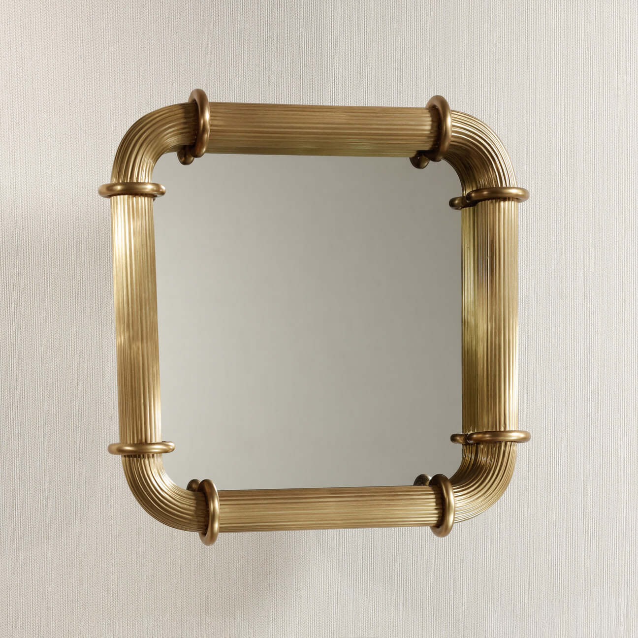 Limoges Ribbed Wall Mirror with ribbed brass frame and circular ring fittings.