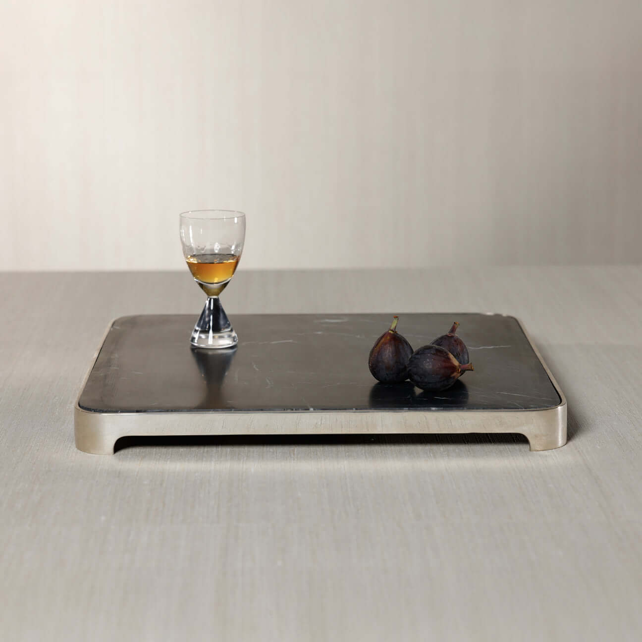 London Cheese and Charcuterie Marble Serving Tray with a glass and figs on a sleek black marble surface