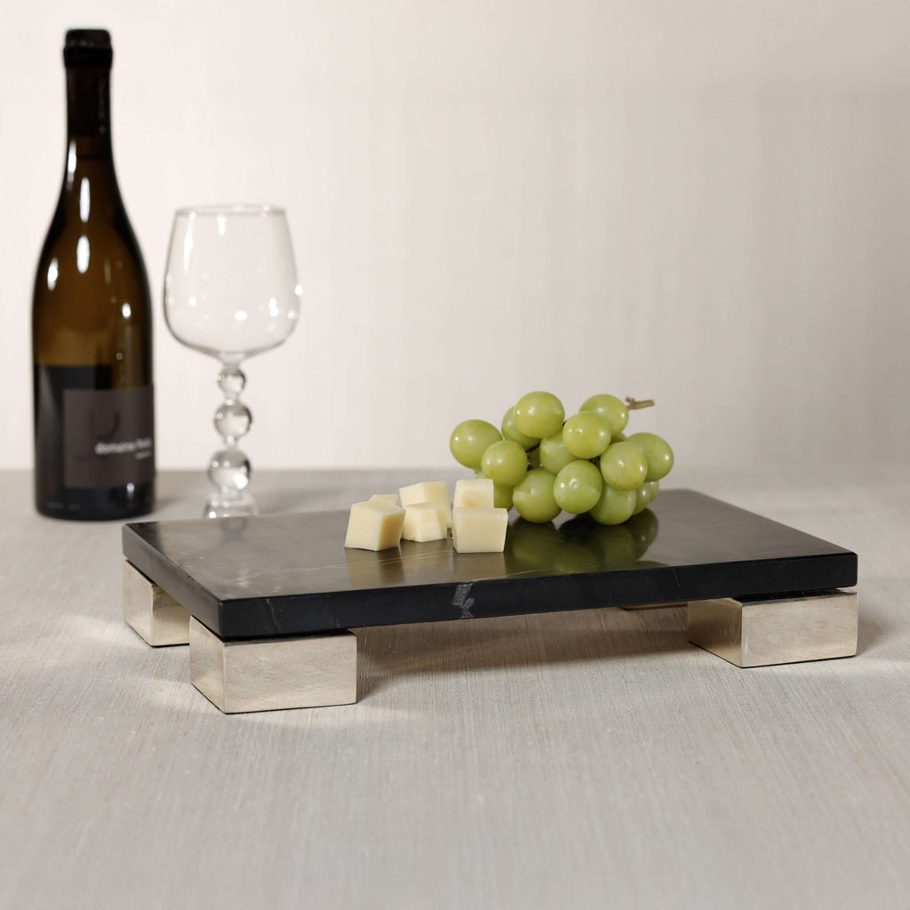 Roku Cheese and Charcuterie Marble Serving Tray featuring black marble, stainless steel feet, cheese, and grapes.