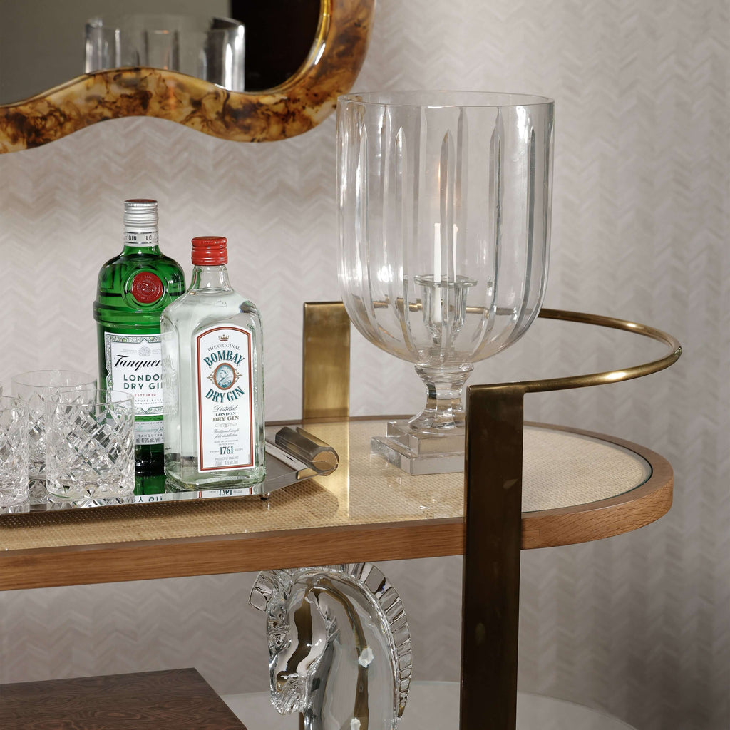 Sloane Oak Wood Oval Bar Cart showcasing bottles and elegant glassware.