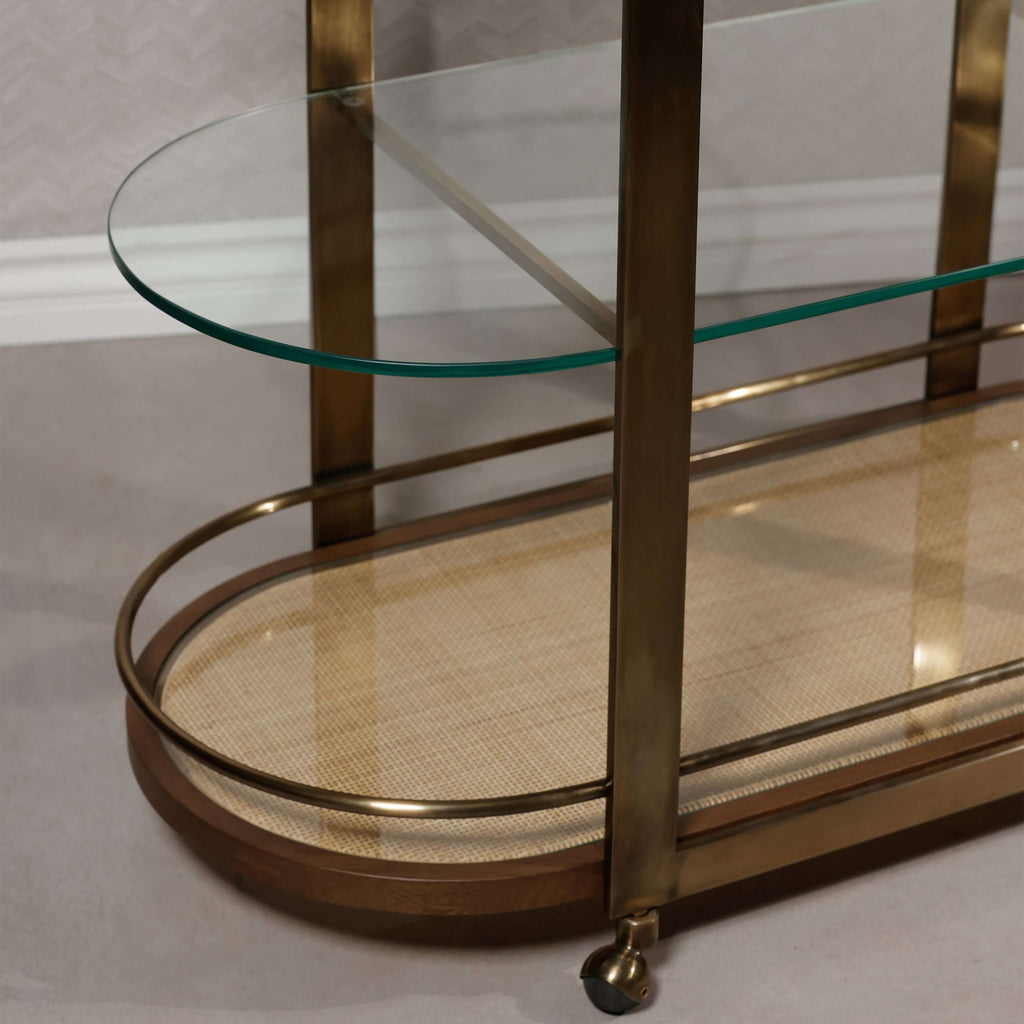 Sloane Oak Wood Oval Bar Cart featuring antique brass-finished steel frame and clear glass shelves.