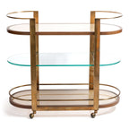 Sloane Oak Wood Oval Bar Cart featuring antique brass frame and glass shelves.