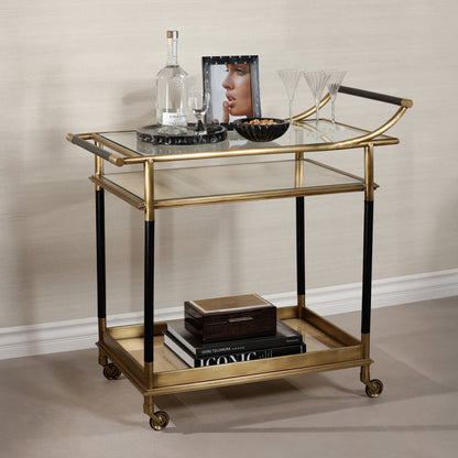 Gold and black serving cart with decorative items on a neutral background