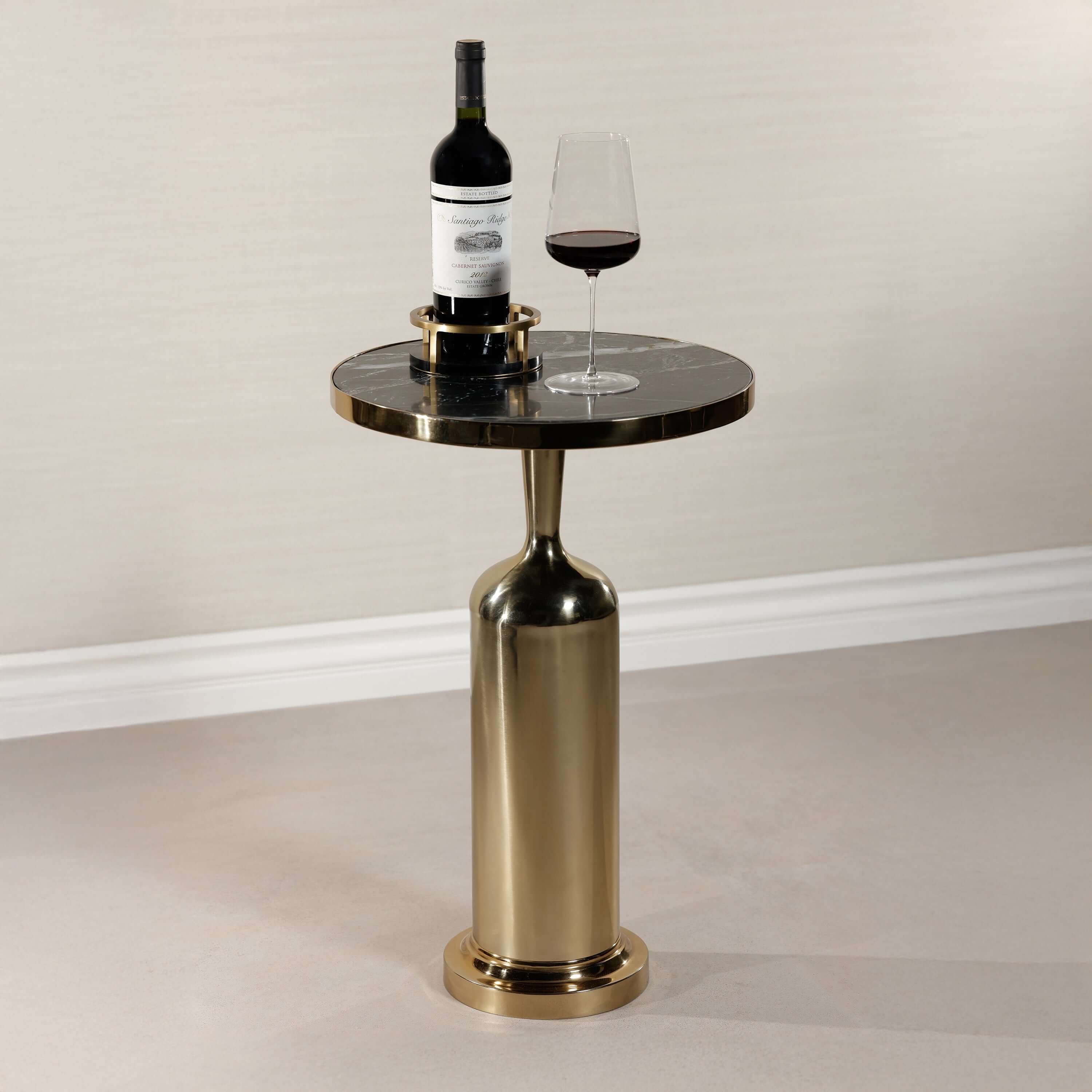 Nomad Table with nero marquina marble top, polished gold rim, and brass-finish pedestal base, perfect for modern decor.