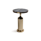 Nomad Table featuring a thick round nero marquina marble top and a polished gold rim on a brass pedestal base.