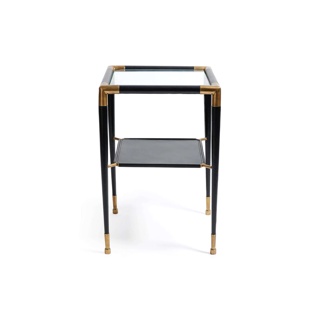 Peninsula Leather Side Table featuring a black leather finish, glass top, and polished brass details.