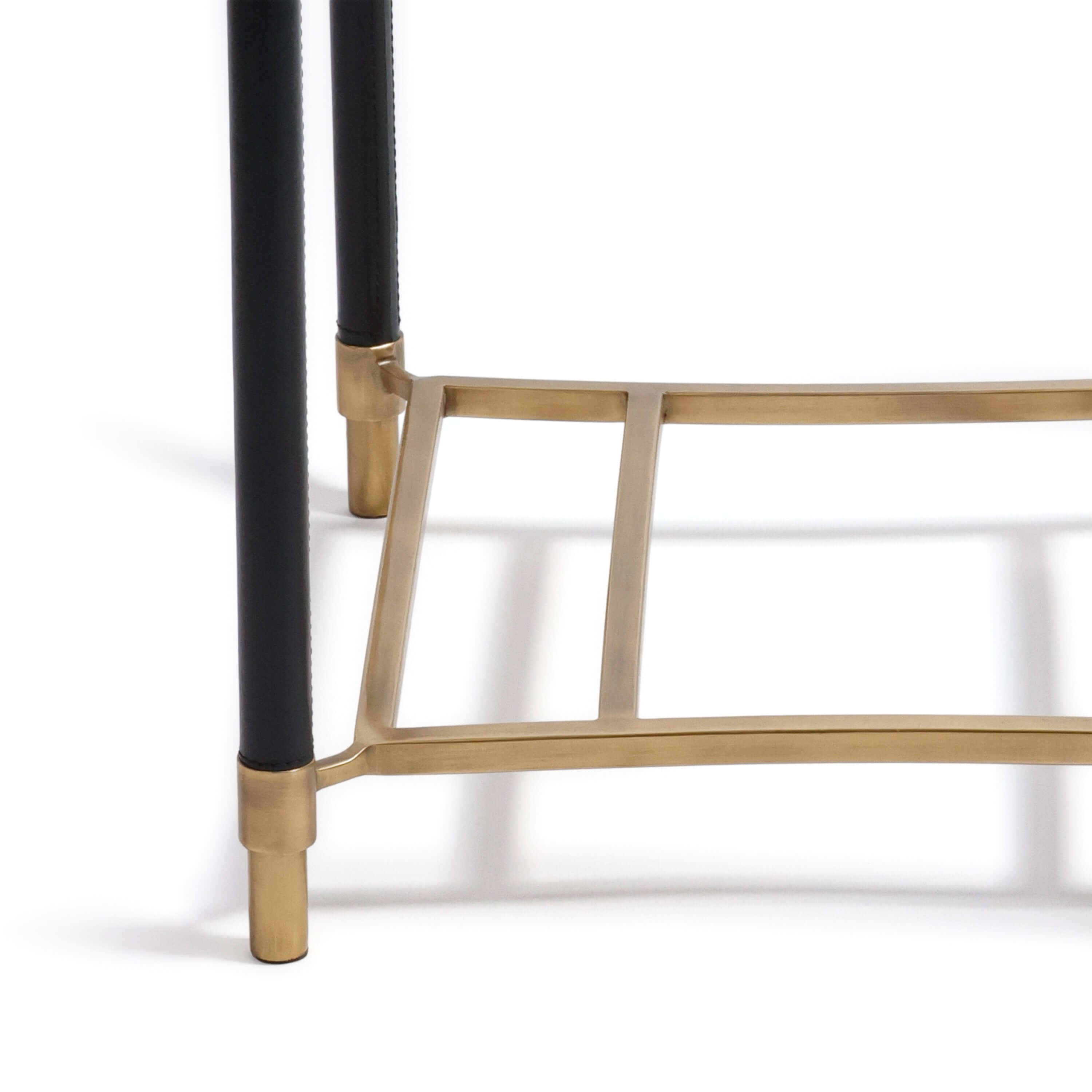 Detail of the Park Lane 18 Leather Side Table showcasing saddle-stitched black leather and brass collar fittings.