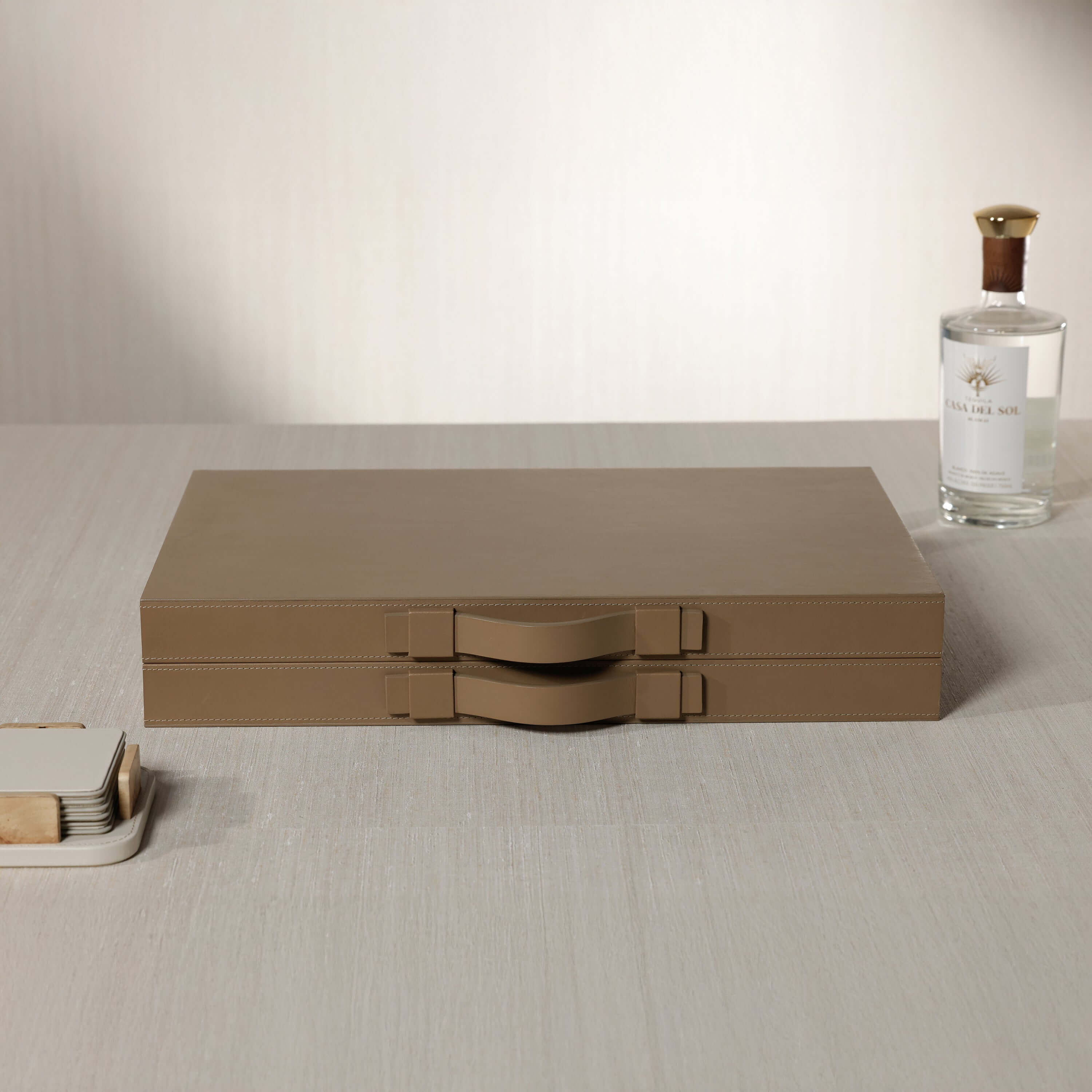 Geneva 19" Backgammon Set - Taupe Leather case with handles on a wooden table.