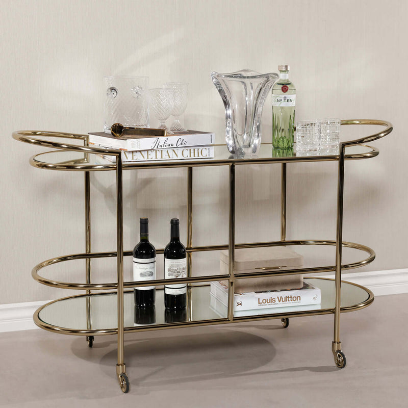Lido Console Bar Cart featuring champagne brass frame and decorative glassware.