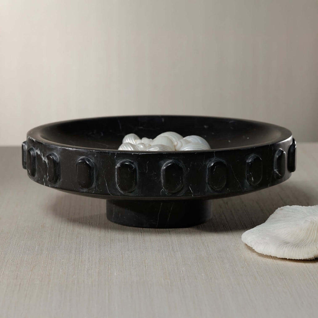 Black Marquina Marbella Bowl featuring elegant carved medallions and delicate white decor.
