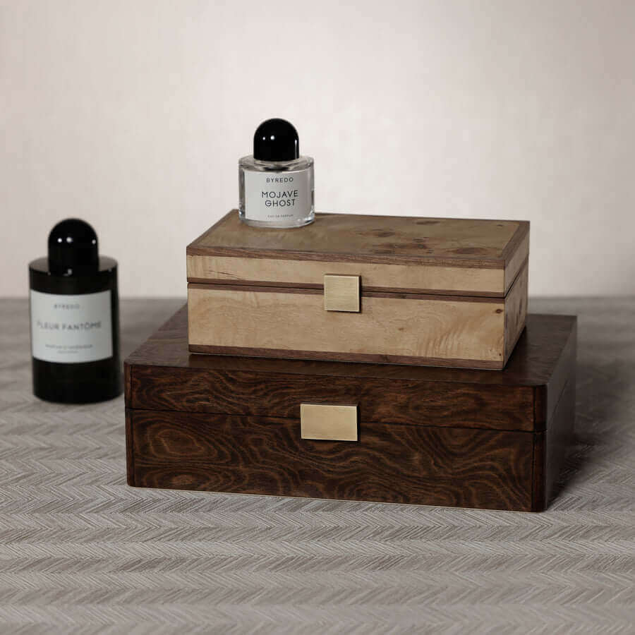 Linea Heritage Burl Veneer Jewelry Box displayed with candles and perfumes on a textured surface.