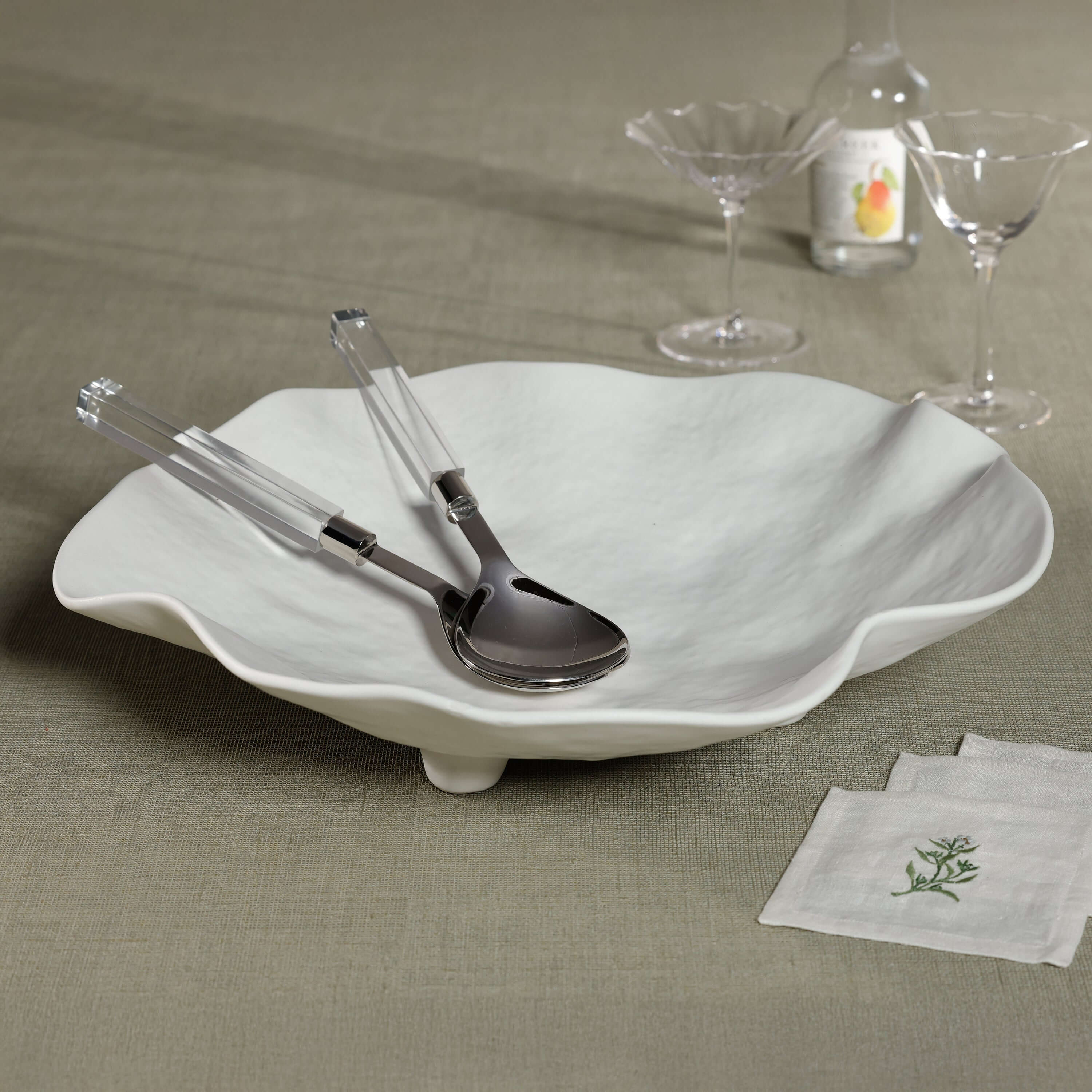 Mougins Salad Server Set with Acrylic Handle displayed on a stylish white bowl with glassware.