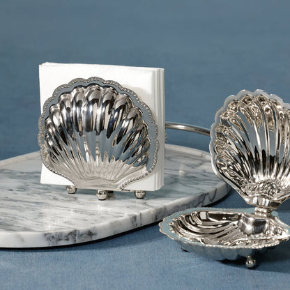 Silver shell-shaped salt and pepper shakers on a marble base with a blue background