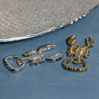 Lobster Bottle Opener in polished silver and gold finishes displayed on a table with a textured plate.