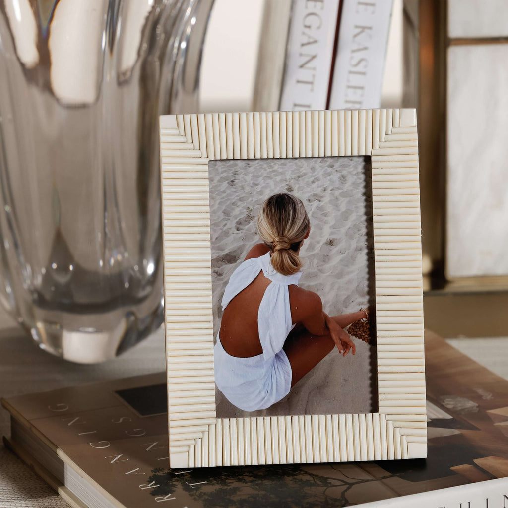 Nubia White Bone Ribbed Photo Frame displaying a photo against a sandy beach background.