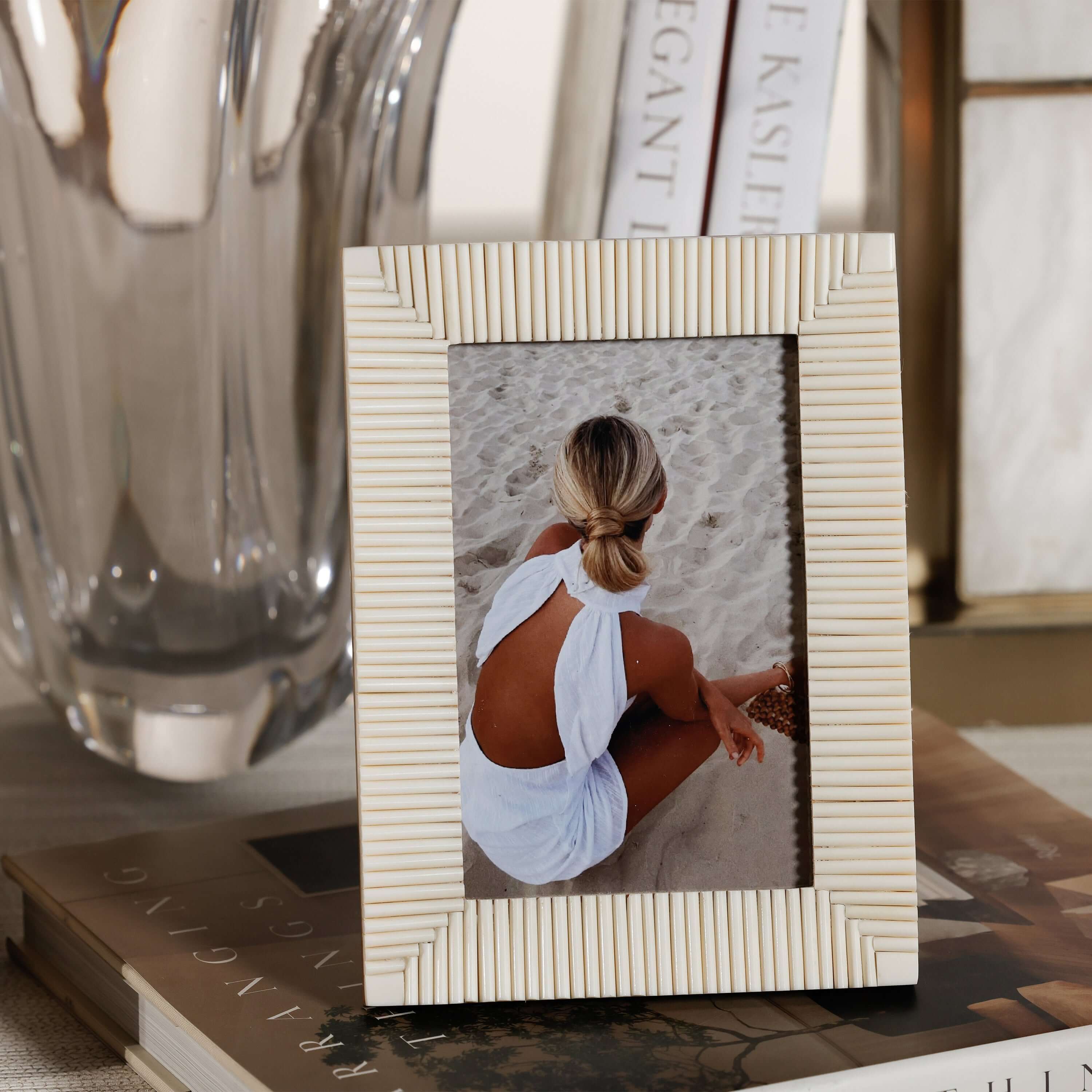 Nubia White Bone Ribbed Photo Frame displaying a photo against a sandy beach background.