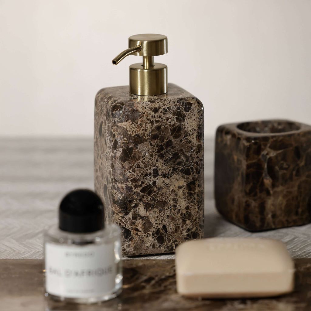 Marrón Emperador Marble Bath Collection soap dispenser and accessories on a marble surface.