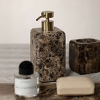 Marrón Emperador Marble Bath Collection soap dispenser and accessories on a marble surface.