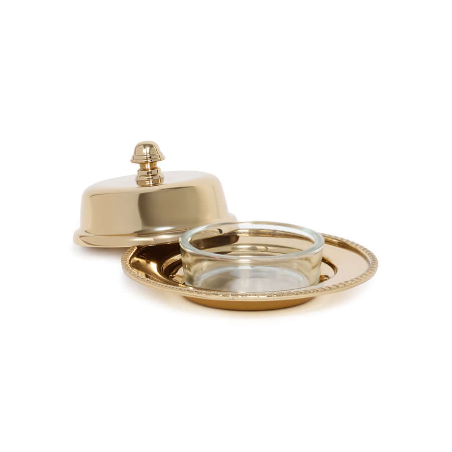Gold serving dish with lid and glass container on a white background