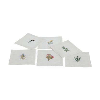Set of six white napkins with floral embroidery on a white background