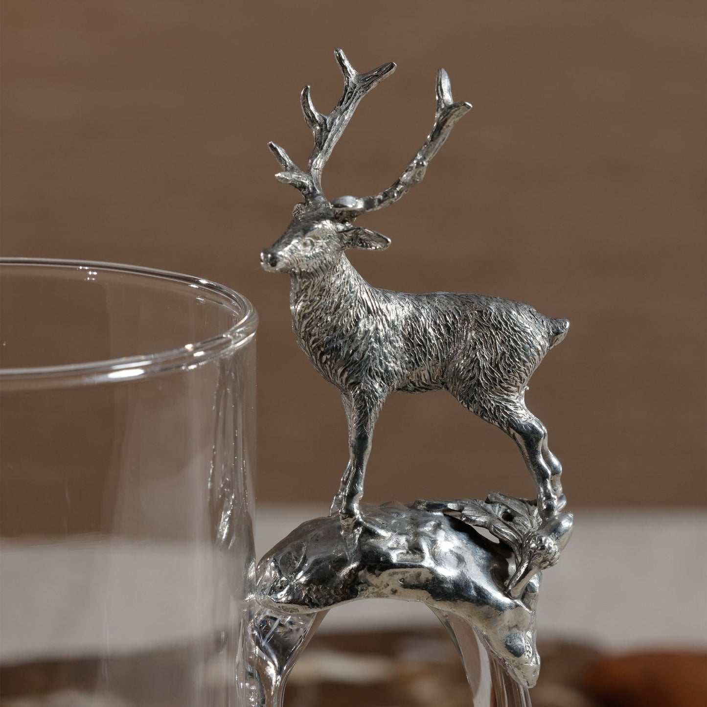 Silver deer figurine on a glass with a blurred background
