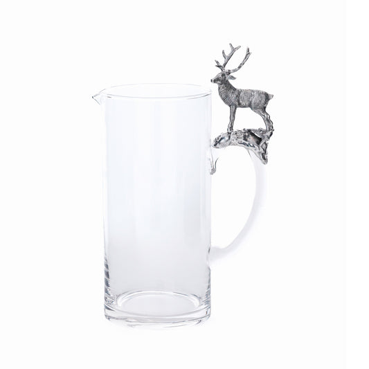 Clear glass pitcher with a metal deer finial on a white background