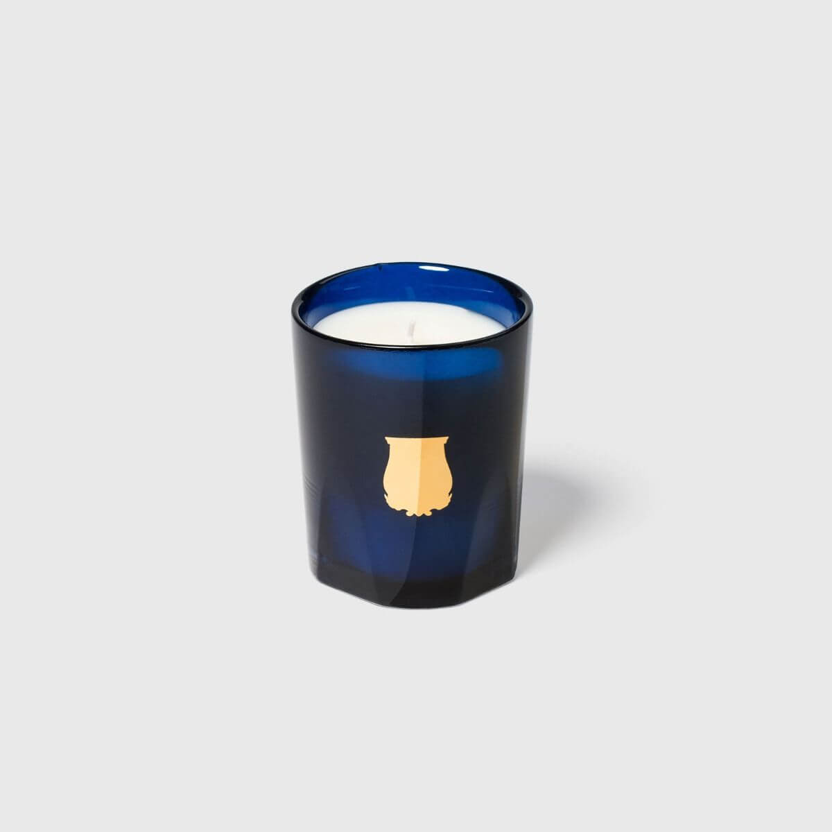 Madurai Petite Candle in a blue glass holder, featuring a stylish design, handcrafted and offering a luxurious ambiance.