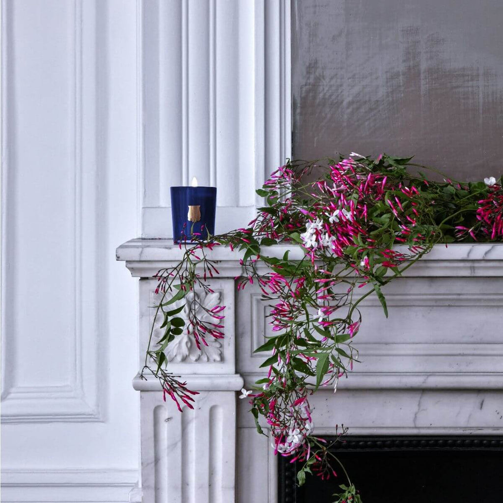 Madurai Petite Candle on a marble mantel adorned with pink flowers, enhancing elegant home decor.